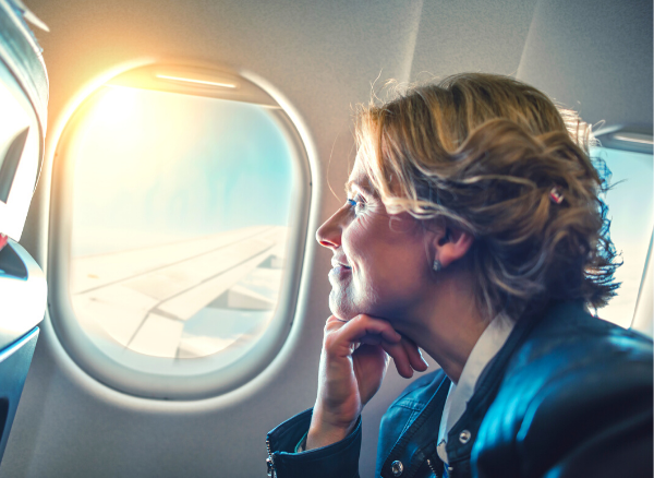 Business traveler looking at clouds out of airplane window